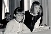 Elever födda 1955 sittandes vid sina skolbänkar i klassrummet på Kålleredsskolan/Brattåsskolan cirka 1965/70. 
Från vänster: Ulla-Carin Holmberg (Bölet), Katarina Jägrud (Vommedal) och i bakgrunden till vänster Gunnar Adås.