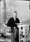 Ateljéporträtt - man sitter vid ett bord med en bok, Östhammar, Uppland