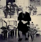 Hulda Hansson (1876 - 1975) blir uppvaktad med blommor, här på ett sjukhem okänt årtal. Hon arbetade som hushållerska hos konsul Kindal på Vasagatan i Göteborg. Han ägde Gumperts bokhandel (se Hembygdsskrift nr 13). Efter pensioneringen bosatte hon sig i sitt föräldrahem Vommedal Västergård 