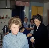 Kyrkokören på besök i Brattåshemmets kök år 1969.
Främst från vänster: Gunvor Eriksson, Sporred (1923 - 1970) samt Anna Lisa Larsson, Vommedal (1917-2007). I bakgrunden ses personal.