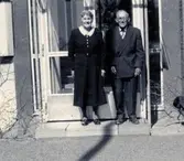 Robert Pettersson (1886 - 1968) uppvaktas på födelsedagen av sin syster (uppgift saknas) som står till vänster. De står utanför Brattåshemmets entré 21/4 1960. Han arbetade som dräng på Ekans gård.