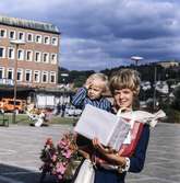 Kvinna med pojke i famnen fotograferade vid Stadshusplatsen i Mölndal, 17/9 1968.