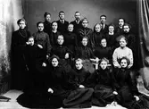 Gruppbild på väverskor vid Alingsås bumillsväveri, gamla fabriken i kvarter Fliten. Föreståndare Glasin står i mitten på översta raden och H.L. Håkansson till höger.