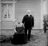 ETT ÄLDRE PAR VID VÄGGEN TILL BROVAKTARSTUGAN.