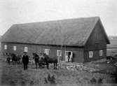 Stor ladugård med halmtak.
Juli 1913.