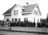Resenärer vid stationshuset i väntan på tåget för resa till Kinnekulle i oktober 1915.