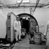 Varvet runt- en bildutställning
Varvet har under flera år deltagit i de årliga underhållsarbetena vid kärnkraftsverk. Filaren Lasse Svensson framför den massiva dörren till en av reaktorerna i kärnkraftverket i Oskarshamn 1972.