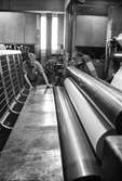 Man i arbete vid maskin på pappersbruket Papyrus, hösten 1970. Rullmaskin 5, byggnad 10. Lars Elfström, jobbade som arbetsledare.