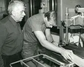 En skolelev som använder bandsåg under överseende av läraren i Ekenskolan 1986-02-05.