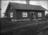 Torp med kvinna och barn på trappan, ca 1910.