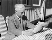 Man sitter ute och läser tidningen, Östhammar, Uppland