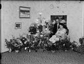 Kvinna och man i bostadsmiljö omgiven av blommor, Östhammar, Uppland