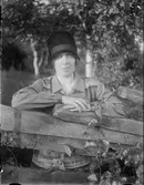 Kvinna i hatt vid staket, Östhammar, Uppland