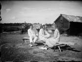 Josef, Sara och Tyra Edhlund sitter på en bänk, Östhammar, Uppland