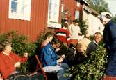 Flätning av lövmattor utanför Långåker Hembygdsgård våren 1983. Från vänster: 1 Maj Britt Andreasson, 5 Sigbritt Johansson (på trappan), 8 Henrik Lundell samt 9 Mary Ekman. Övriga är okända.