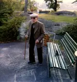 Sjömannen Knut Hagberg (1885 - 1980), med solglasögon och käpp, står vid en bänk utanför Brattåshemmet våren 1979. Född i Haga församling i Göteborg 31/12 1885, där föräldrar hade speceriaffär. Han gav sig av år 1903 och besökte alla världsdelar. Han återkom till Kållered omkring 1930 från Antwerpen och bodde i sin syster Valdeborg Johanssons hus på Streteredsvägen 12. Hans mor Johanna Eriksdotter var född i Vommedal Östergård 