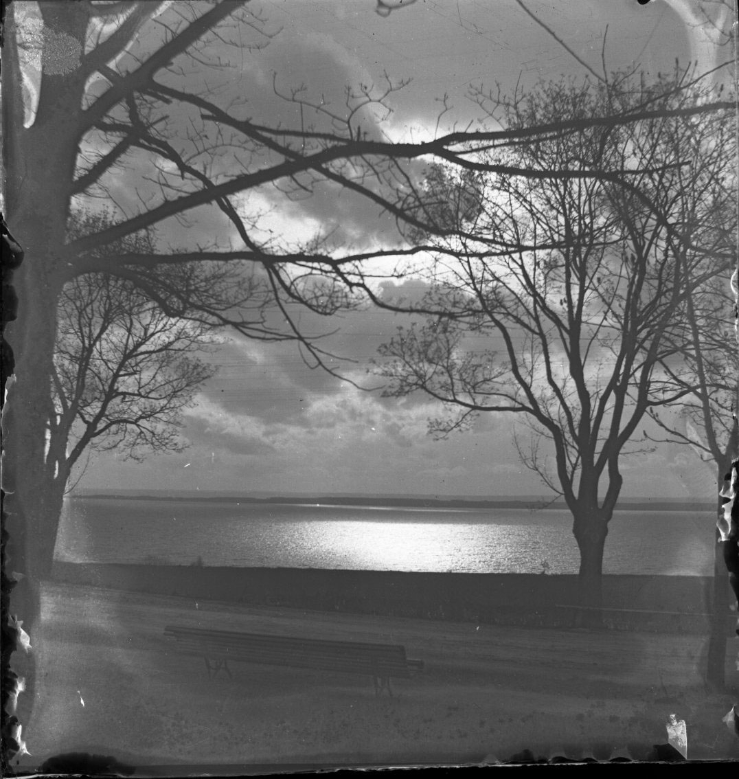 Unknown artist, Solnedgång över Vättern strax utanför Söder tull. Mycket moln på himlen.