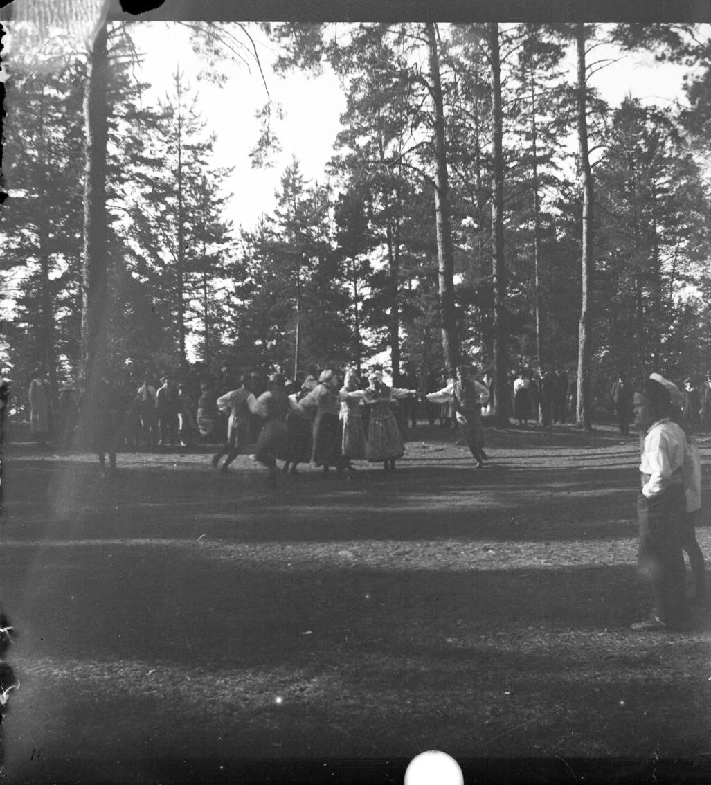 Unknown artist, Folkdans på en gräsplan bland höga tallar. Sannolikt på Grännaberget.