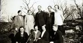 Gruppbild i en skogsbacke av Karl Larsson i Albäck, stående i mitten, med familj. Klänningarna är lågt skurna enligt 1930-talets mode och flickan längst till höger har samlat en fläta likt en ros vid örat.
