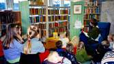 Sagostund för barn med bibliotiksassistent Ingrid Hansson (sittandes i fåtölj) på Kållereds bibliotek 1990-tal.