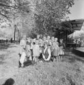 Gruppbild. Två kvinnor och barn iklädda folkdräkt. Skansen.