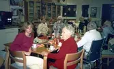Fikastund i dagcentralen på Brattåsgården (Streteredsvägen 5) cirka 1987. Sittandes, andra person från vänster: terapibiträde Ingela Bengtsson (i ljus tröja). Övriga namnuppgifter saknas.