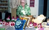 Julförsäljning av hantverk i pensionärernas hobbylokal på Våmmedalsvägen år 1977. Berta Mattsson (1910 - 2013) står bakom ett bord. Berta arbetade i Centralköket på Stretereds skolhem. En av de första kvinnorna i Kållereds Kommunalfullmäktige och engagerad i Kållereds Socialdemokratiska kvinnoförening. Enligt uppgift älskade hon att väva mattor och baka goda ”Drömmar”.