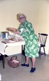 Julförsäljning av hantverk i pensionärernas hobbylokal på Våmmedalsvägen år 1977. Berta Mattsson (1910 - 2013) står vid ett bord.