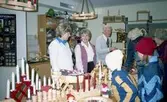 Julförsäljning av hantverk i pensionärernas hobbylokal/träffpunkt på Våmmedalsvägen år 1982. Från vänster står 1. Ingela Bengtsson, terapibiträde. 2. Britt Johansson Norén, terapibiträde. 3. Gösta Magnusson. Övriga namnuppgifter saknas.