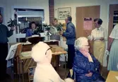 Brattåsgårdens hobbylokal på Vommedalsvägen år 1987. Bakre från vänster: diakon Stig Ove Dahlgren (med ros i handen), Rose-Maj Ekström, Stina Svensson, Ivar Andersson och Alma Persson.
Främst från vänster: okänd man samt Rut Göransson.