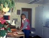 Vårdbiträde Lillvor Sjöström står i Brattåsgårdens reception, cirka 1986 - 1990.