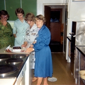 Kökspersonalen efter räkfesten för boende och anhöriga i Brattåshemmets kök (Brattåsvägen 6) 1980-10-16. Från vänster: okänd, okänd, föreståndare Aina Ekstedt samt Maj. Relaterade motiv: A2201-A2209.