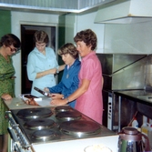 Kökspersonalen efter räkfesten för boende och anhöriga i Brattåshemmets kök (Brattåsvägen 6) 1980-10-16. Från vänster: okänd, okänd, Maj och kokerska Ingela Sjöberg. Relaterade motiv: A2201-A2209.