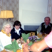 Räkfest för boende och anhöriga i Brattåshemmets matsal (Brattåsvägen 6) 1980-10-16. Sittandes från vänster: två okända kvinnor samt Kondratij Krivtsov (född 1895 i Ryssland, död 1985 i Kållered).