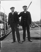 Två män på kajen med varsin blombukett i handen, Östhammar, Uppland