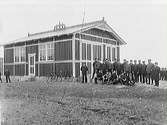 Särdals livräddningsstation i Harplinge socken. 1900-tal. Manskapet (med befäls- eller myndighetspersoner?) uppställda utanför byggnaden.