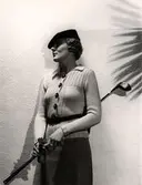 Dammode. Stickat på Nordiska Kompaniet, 21 augusti 1935. Modell med kofta och keps håller i en golfklubba.