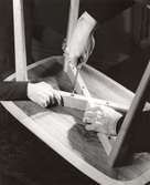 Två par händer monterar underrede på Triva Byggbord på varuhuset Nordiska Kompaniet, Stockholm 1945. Serien Triva Bygg var Sveriges första monteringsbara möbler som levererades i platt paket, komplett med skruvar och beslag.