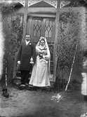 Brudpar stående på yttertrappa. Bröllop i Åsen 24 juni 1903 mellan Fil-Martin Larsson från N. Finnskoga (f. 1872) och Mångs Johanna Andersson från Bärvallen (f. 1866). 