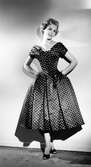 Modell i prickig klänning från NK:s franska damskrädderi. Original från Dior.