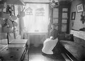 Kvinna i köket i handlare E. Berges hem, Bredgränd 4, Uppsala före 1914
