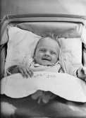 Leende spädbarn i barnvagn, sannolikt Uppsala