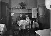 Kvinna och man vid köksbord, sannolikt Uppsala 1933
