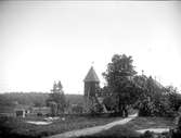 Klockstapel och kyrkomiljön vid Vada kyrka, Vada socken, Uppland i juni 1920