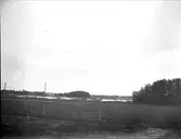 Landskapsvy med ängsmark och sjö i Tegelsmora socken, Uppland, september 1915