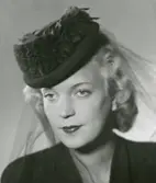 Porträtt av kvinna i mörk hatt med flor, från Madame Suzy.