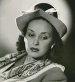 Porträtt av  kvinna i hatt med vitt hattband och scarf, av Otto Lucas.