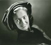Porträtt av kvinna med hatt i brun filt med guldnål.  Hatt använd vid franska avdelningens uppvisning september 1947.