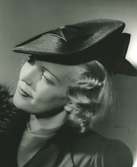 Fb, Porträtt av kvinna i hatt av Jeanne Lanvin. Svart stråhatt med garnering av svart blankt band.