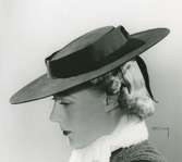 Fb, Porträtt av kvinna i hatt av Paulette de la Bruyère. Svart filt.